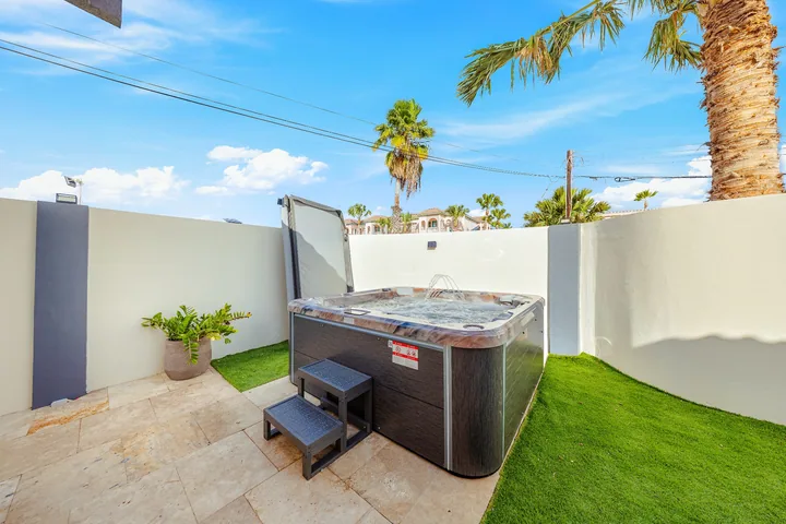 Outdoor jacuzzi with surrounding courtyard garden