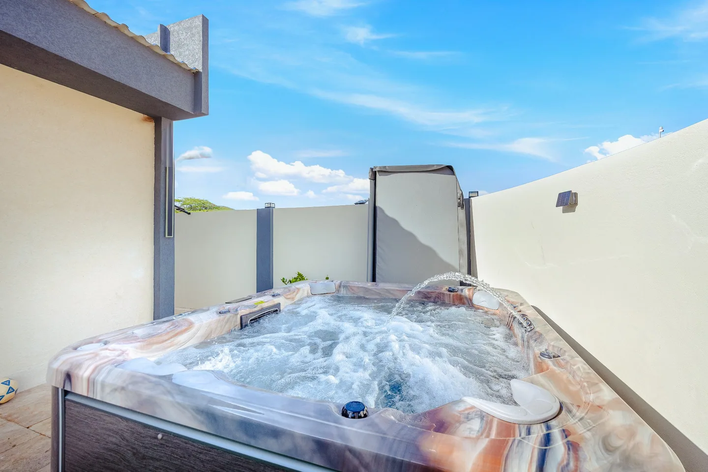 Bubbling outdoor Sea La Vie jacuzzi framed by Aruba sunshine