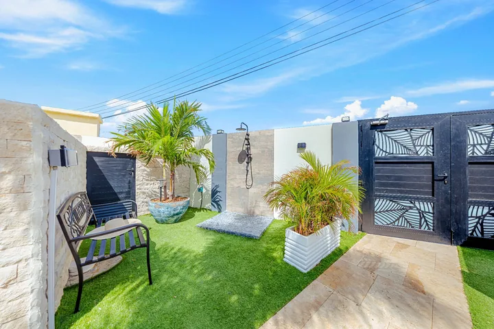 Outdoor shower area beside gated garden