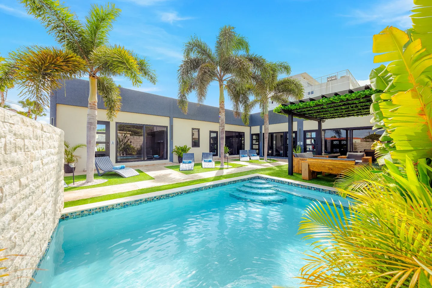 Freshwater swimming pool with palm trees and building courtyard