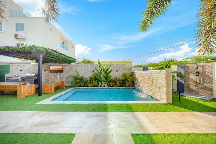 Swimming pool and wall waterfall feature in Aruba courtyard